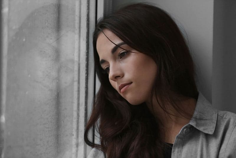 triste jeune femme par la fenêtre