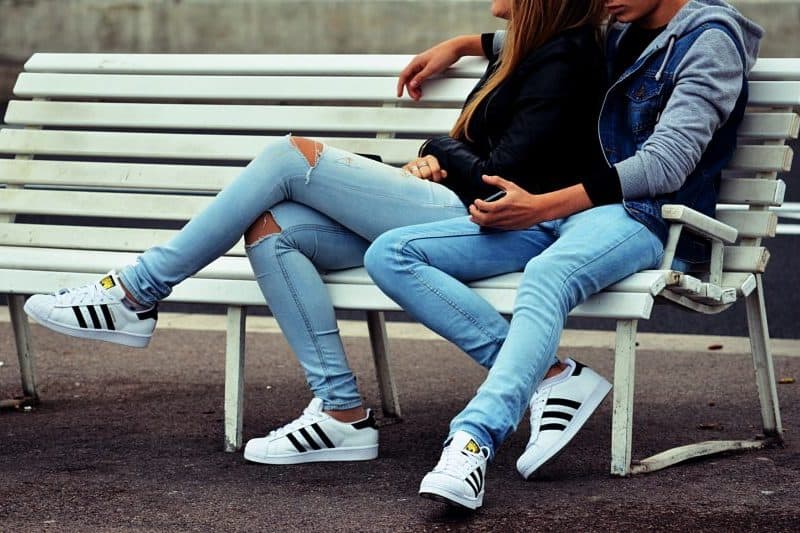 un gars et une fille sont assis sur un banc
