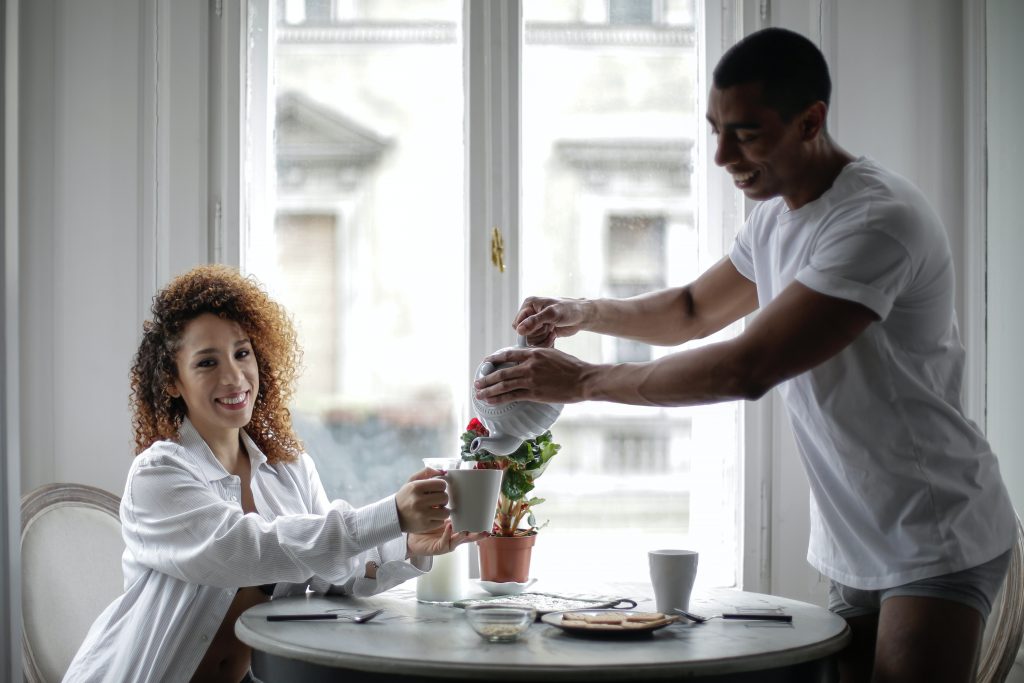 un homme et une femme buvant du café