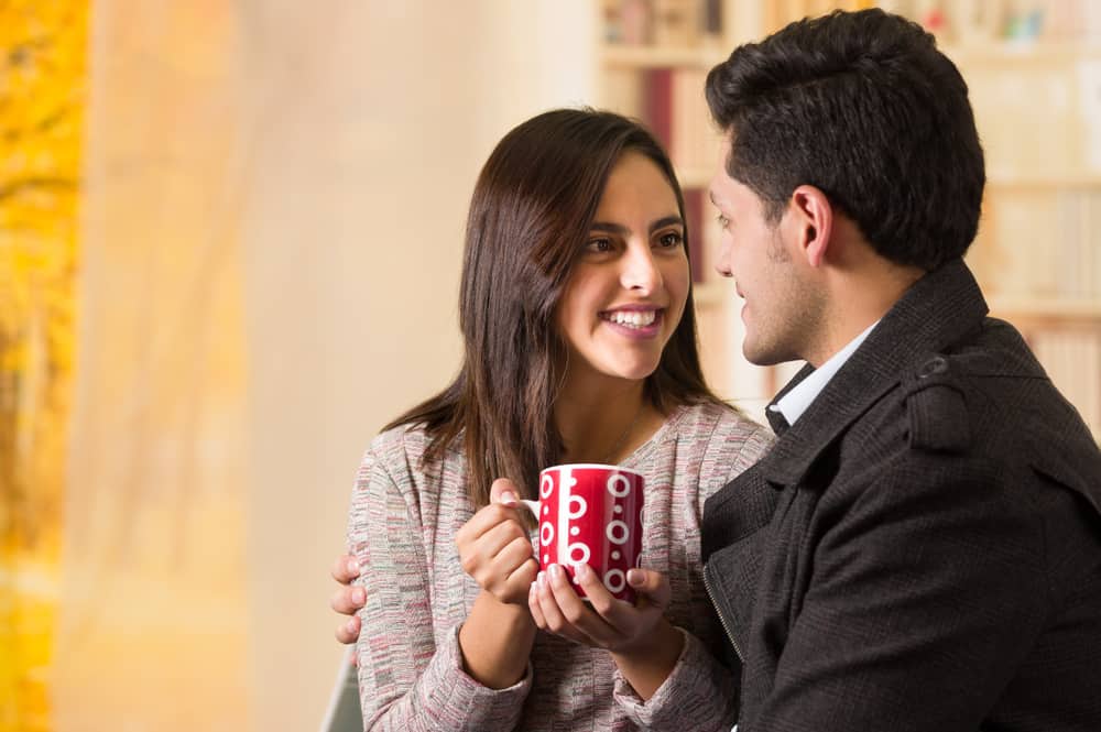 un homme et une femme buvant du café et parlant