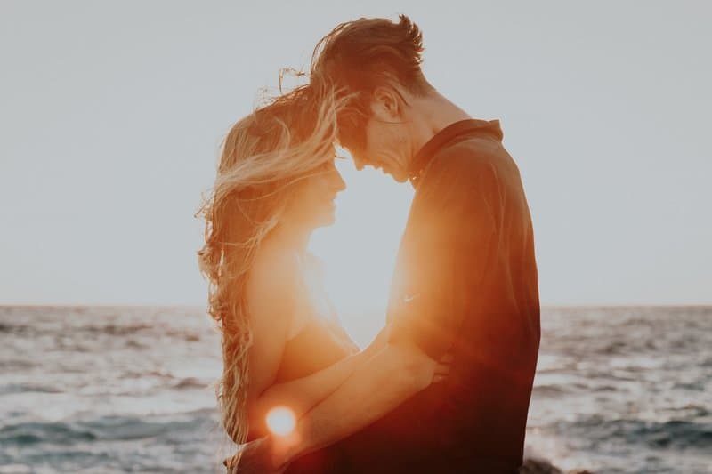 un homme et une femme embrassant au bord de la mer