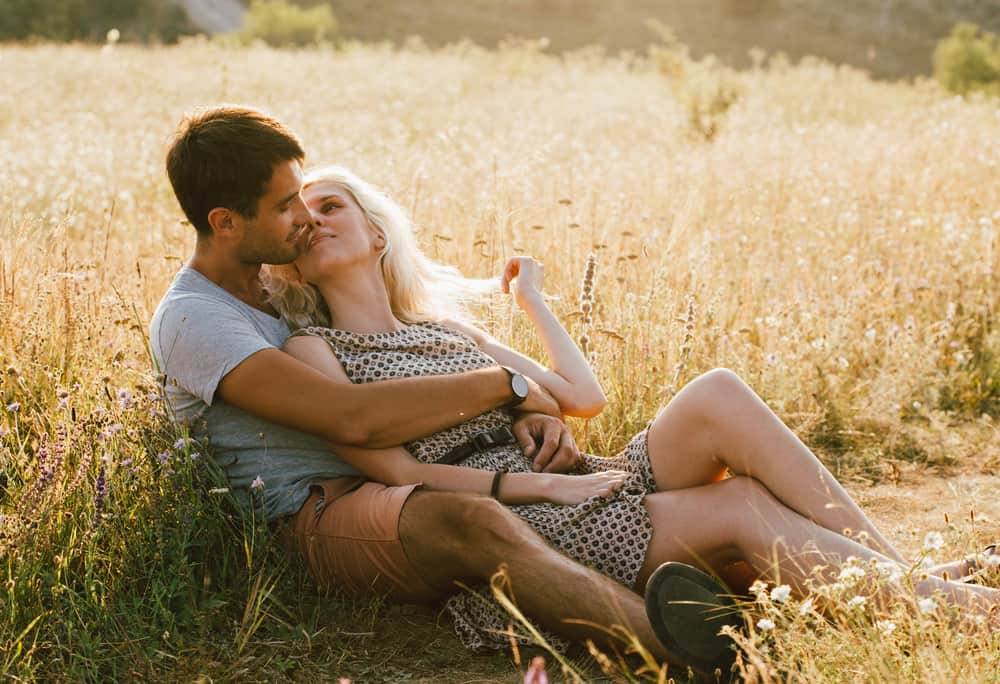 un homme et une femme s'embrassant dans un champ