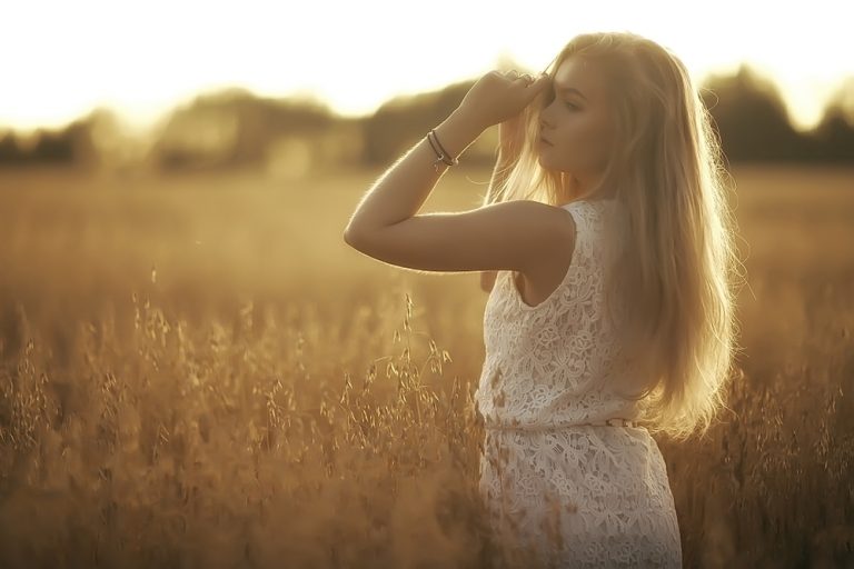 une femme se tient dans un champ de blé