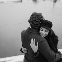 un homme et une femme debout au bord de la mer