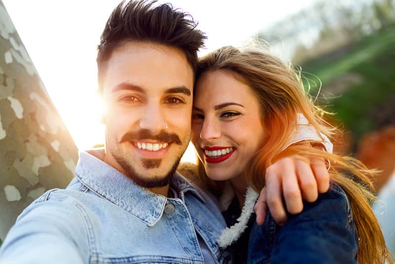 couple, étreindre, et, prendre, selfie, ensemble