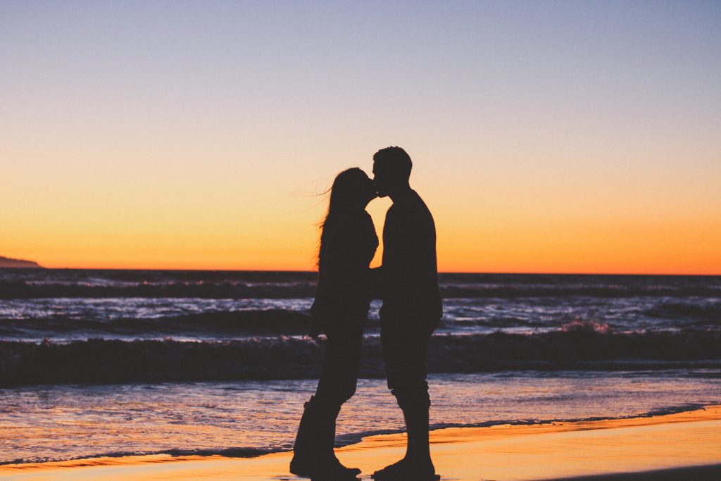 un homme et une femme s'embrassant au bord de la mer