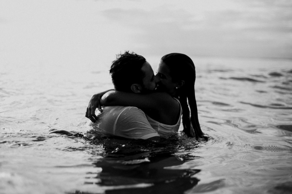 un homme et une femme s'embrassant dans la mer s'embrassant