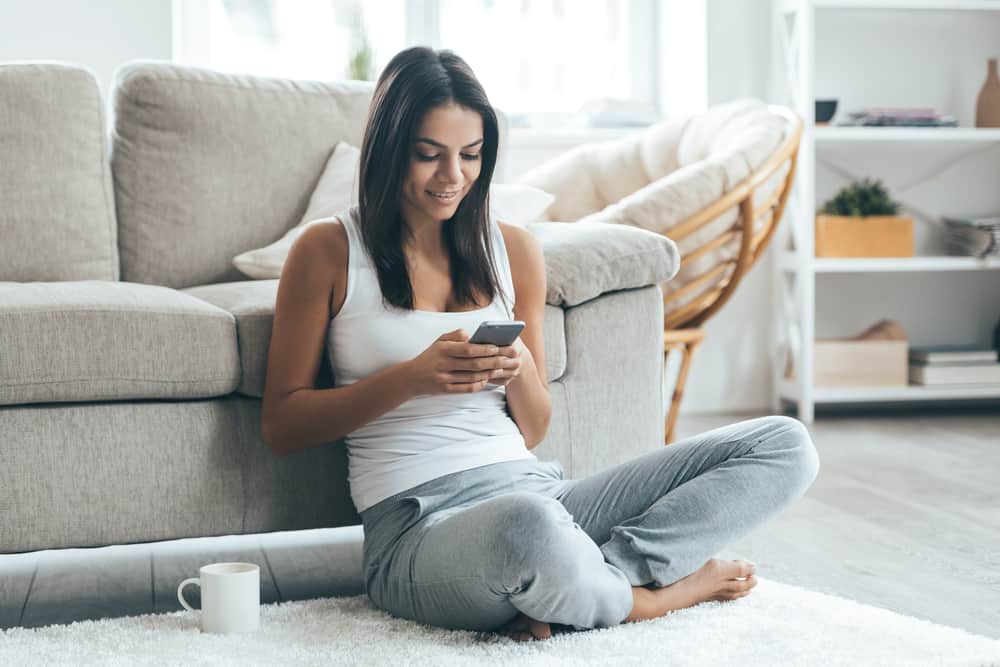 une femme assise avec un téléphone à la main