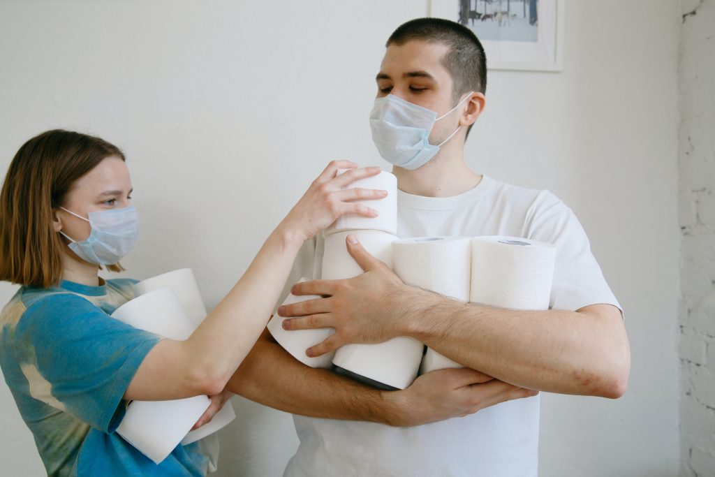 une femme et un homme tenant du papier toilette à la main