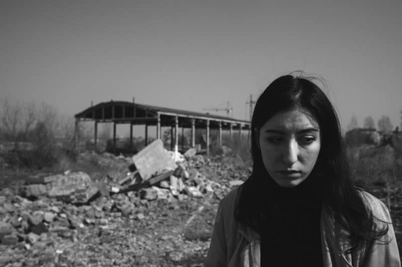 une femme triste à côté des ruines