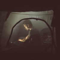 un homme est assis dans une tente