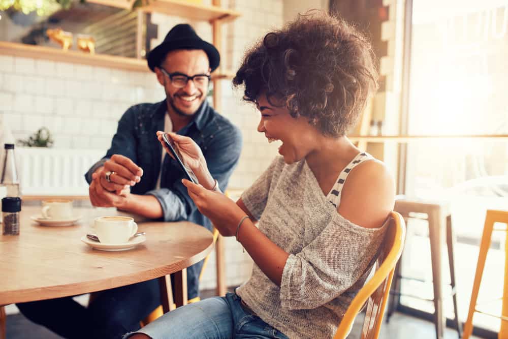 la femme regarde son téléphone portable et rit