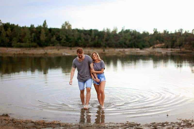 un homme et une femme marchent sur la rivière main dans la main