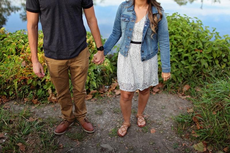 un homme et une femme se serrent la main au bord de la rivière