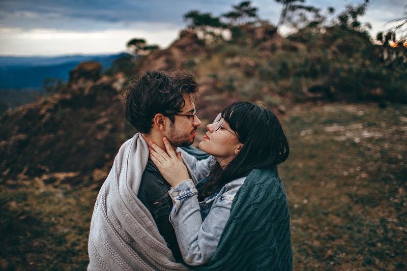 un homme et une femme sur la montagne embrassés