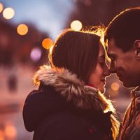 jeune couple s'embrassant au coucher du soleil