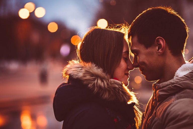 jeune couple s'embrassant au coucher du soleil