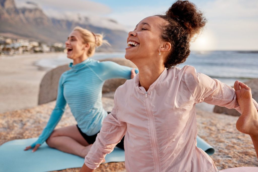 amies souriantes exerçant sur la plage