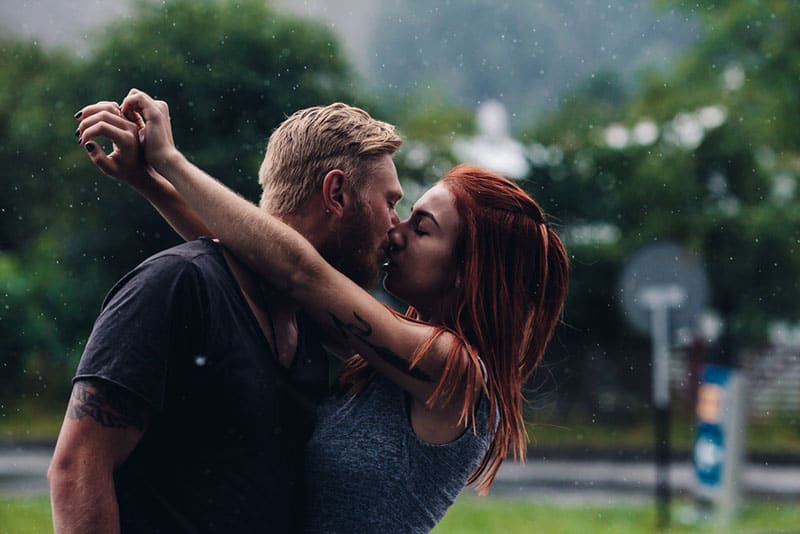 jeune couple s'embrassant sous la pluie
