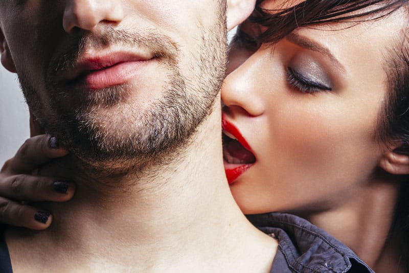 jeune femme embrasse l'homme sur le cou