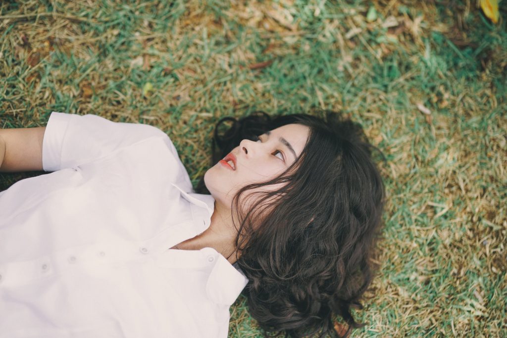 la femme est allongée dans l'herbe