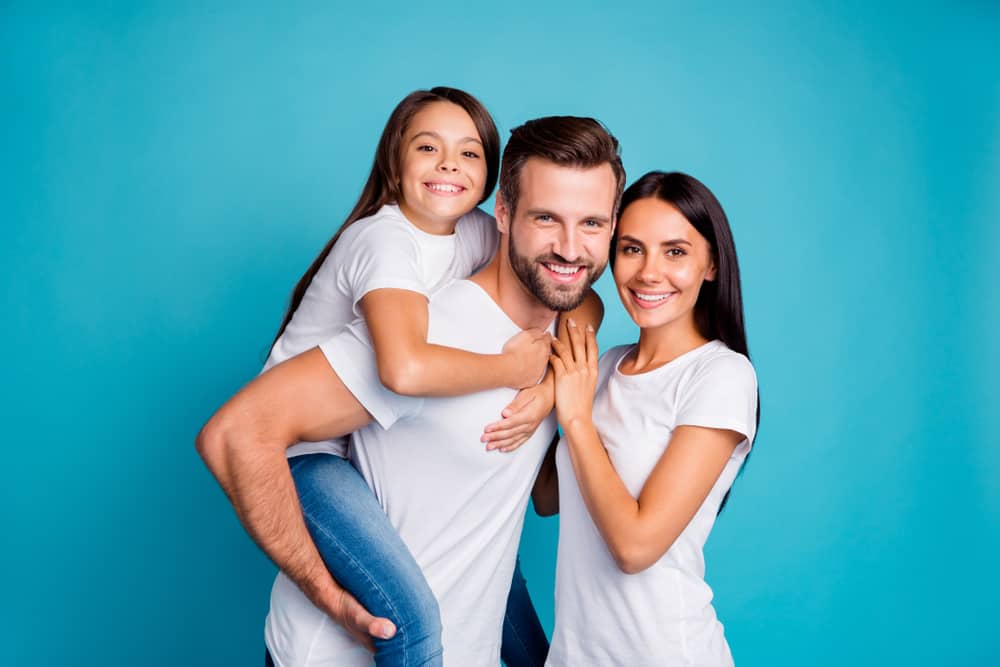 l'homme et la femme se tiennent côte à côte tandis que l'homme embrasse la fille