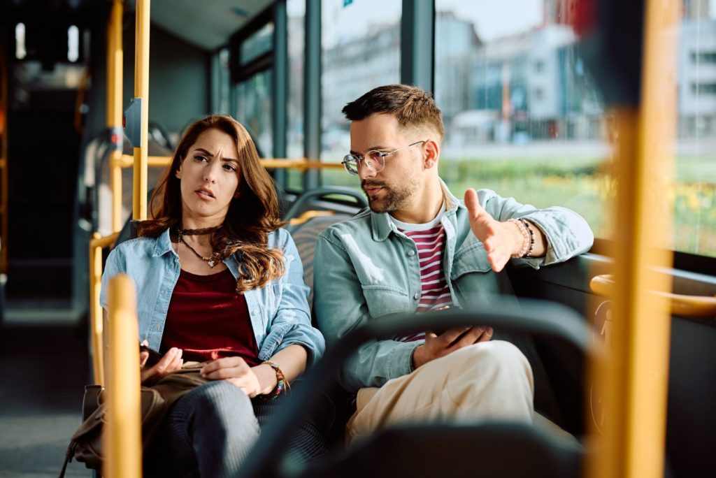 un homme et une femme montent dans un bus et se disputent