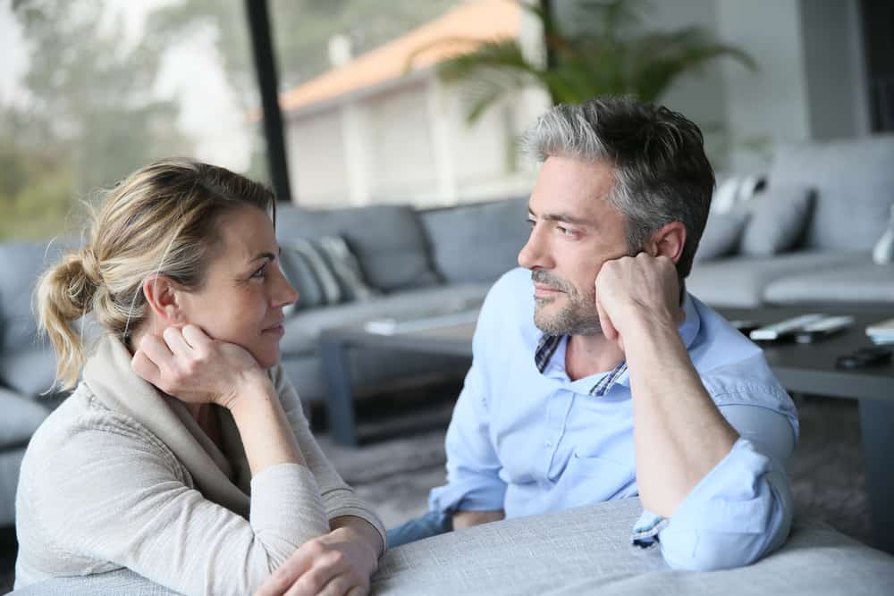 un homme et une femme s'assoient l'un à côté de l'autre et se regardent
