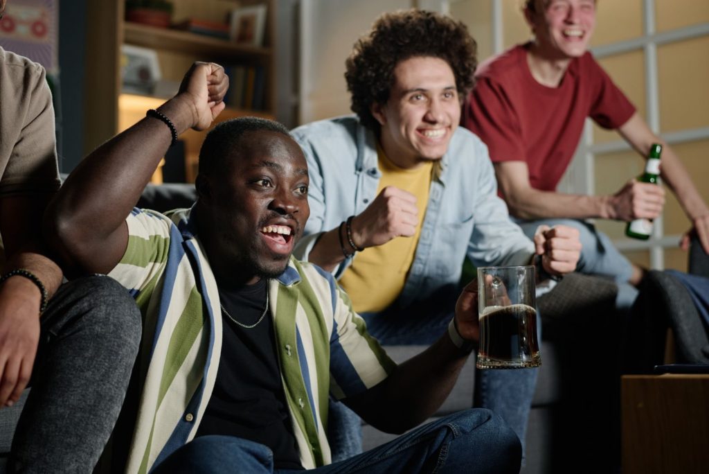 un homme regarde un match avec ses amis