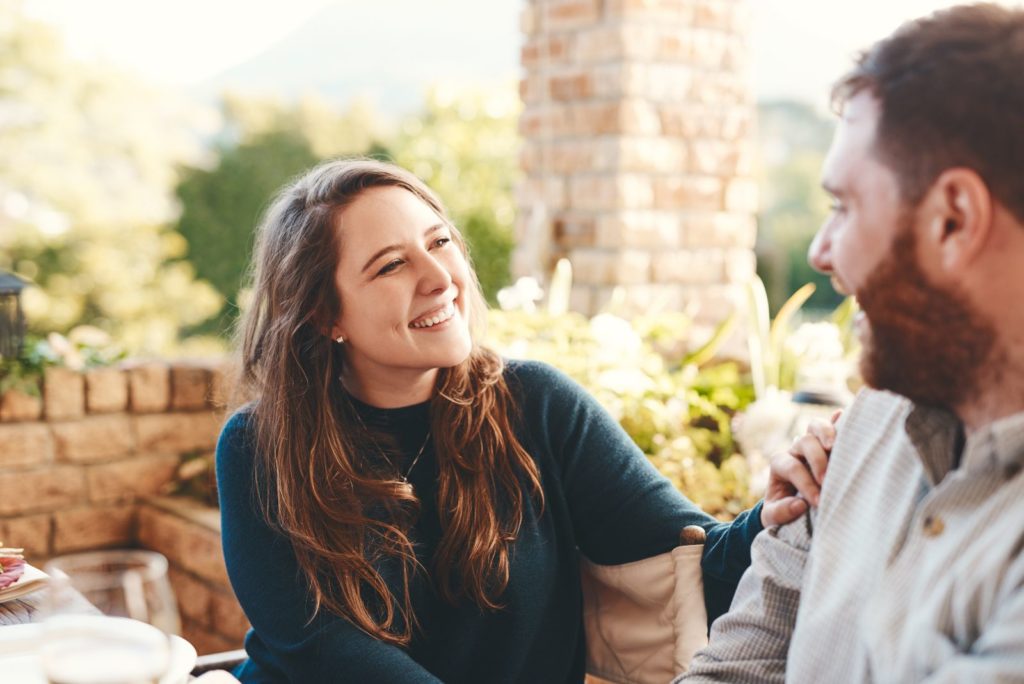 une fille souriante est assise à côté d'un homm