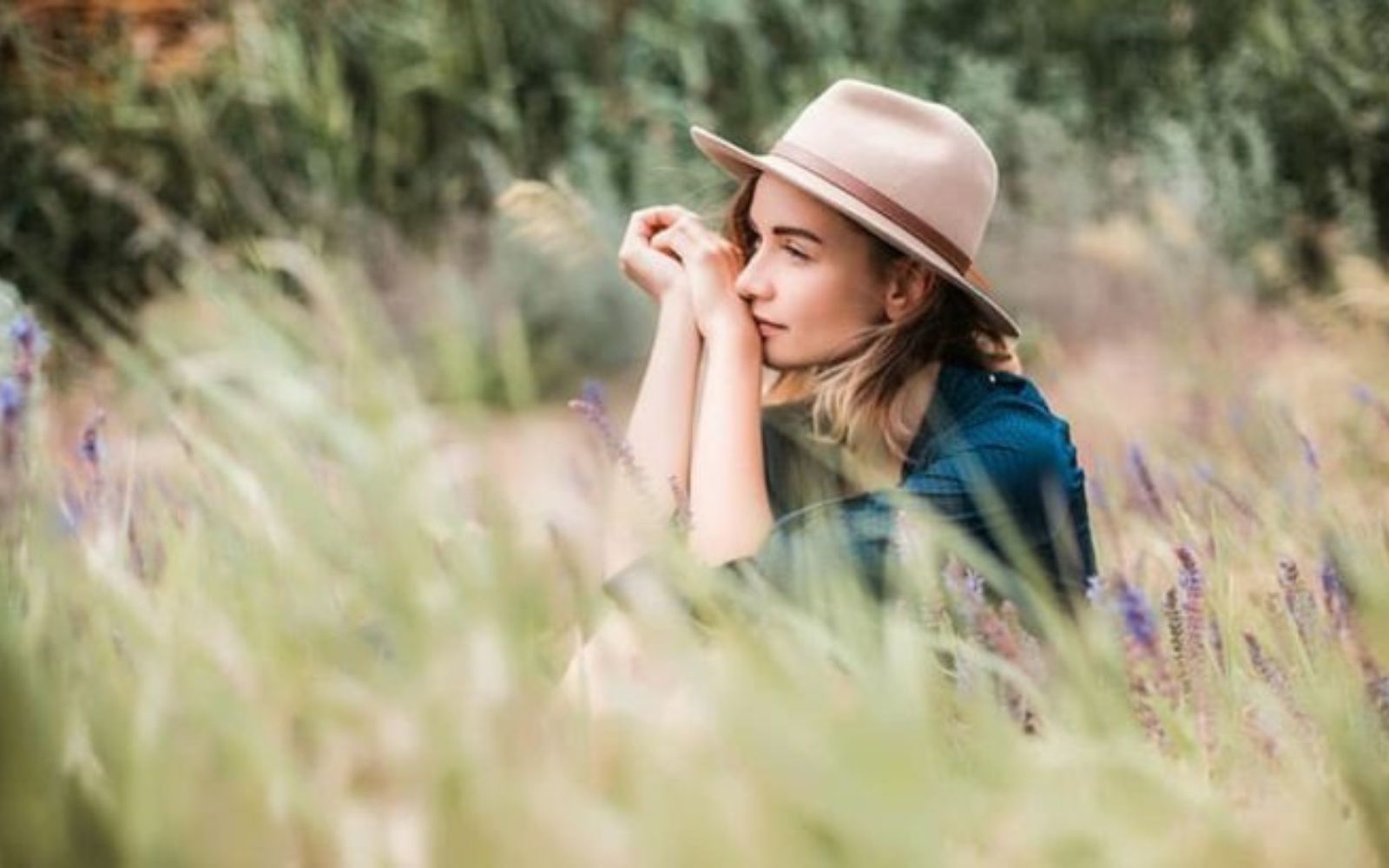 femme assise dans les hautes herbes