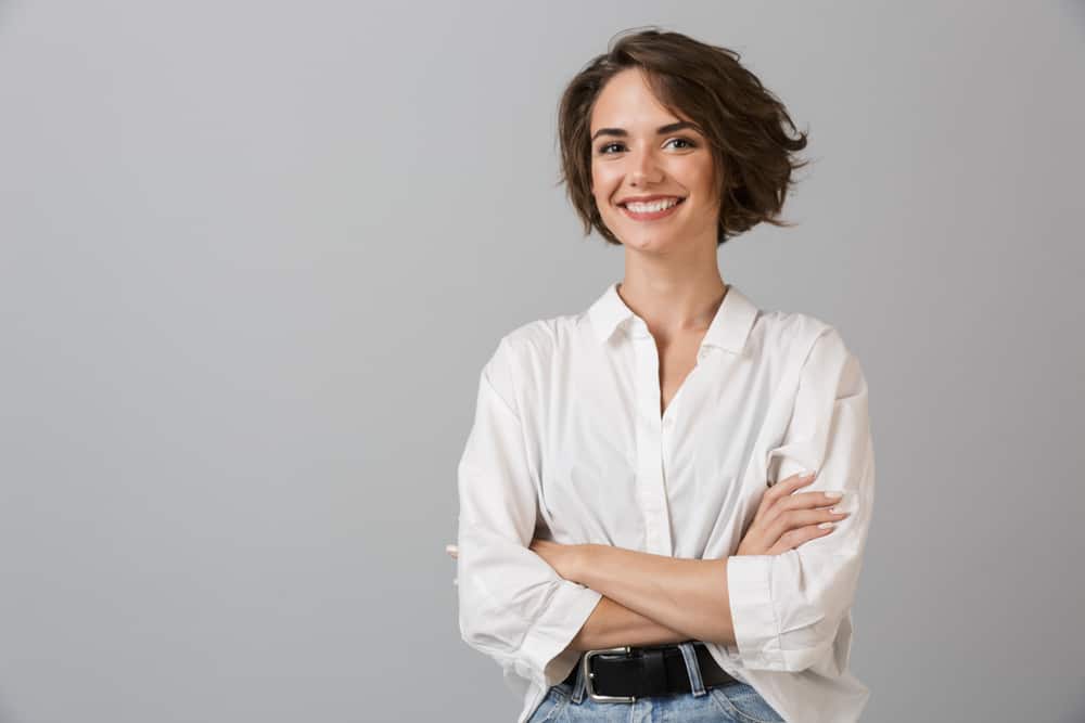 la femme aux bras croisés rit