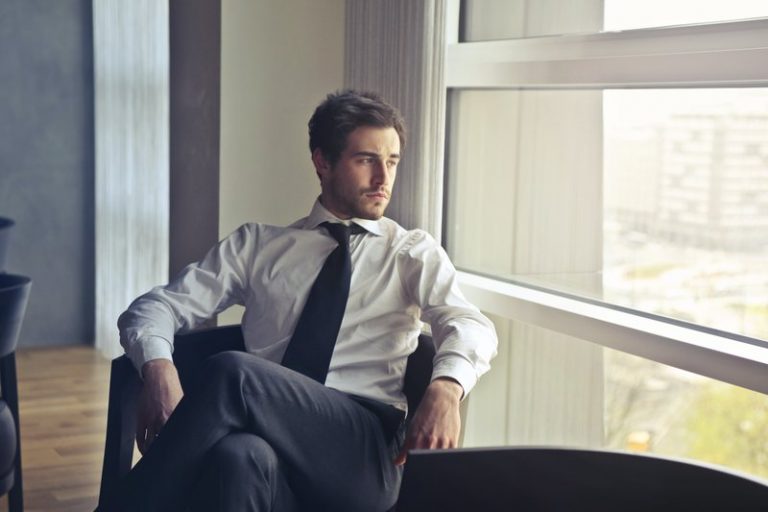 le gars s'assoit et regarde pensivement par la fenêtre