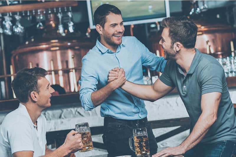 jeune groupe d'amis, boire de la bière dans un bar