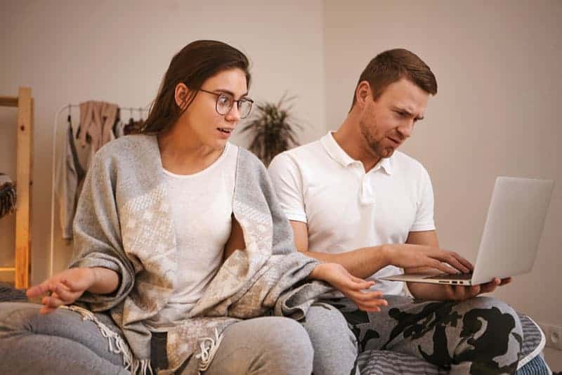 la femme a l'air confuse face à l'homme et à son ordinateur portable