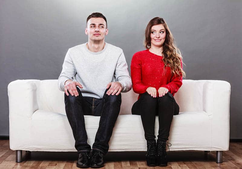 maladroit couple assis sur le canapé