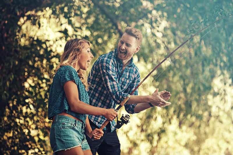 un homme et une femme pêchent et rient