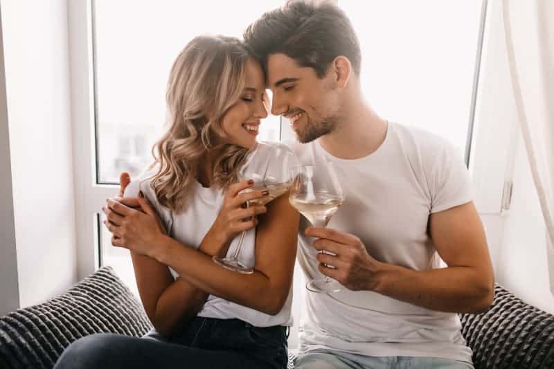 un homme et une femme trinquent avec un verre