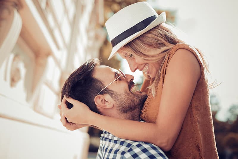 couple étreindre et rire dans la rue