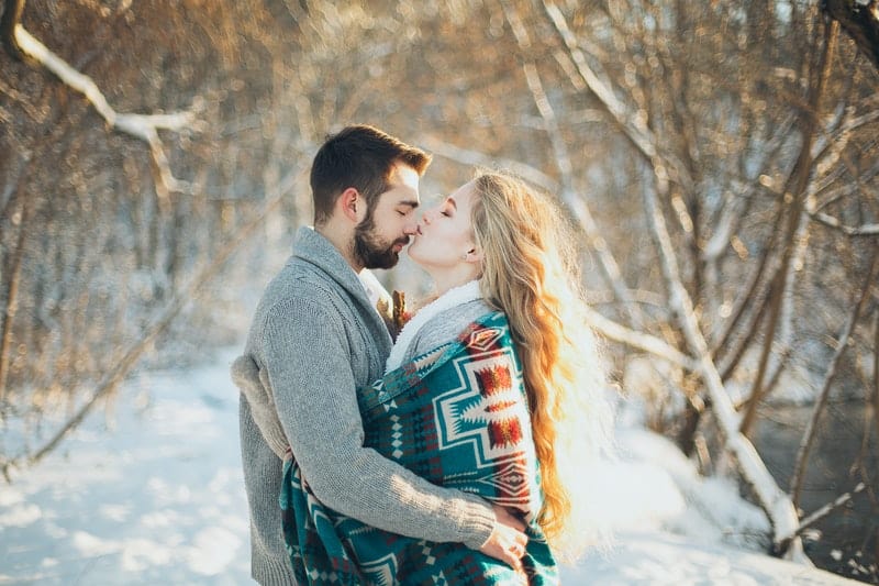 homme et femme s'embrassent passionnément dans la neige