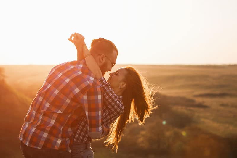 jeune couple, étreindre, dans, coucher soleil