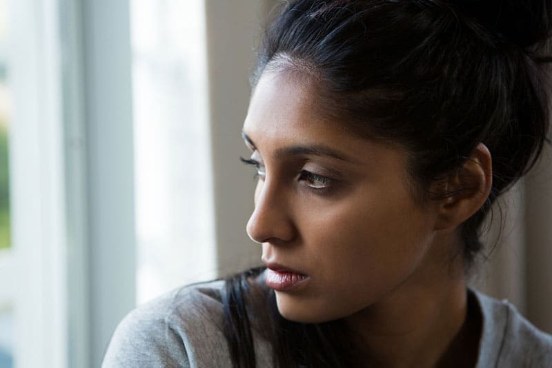 jeune femme triste par la fenêtre