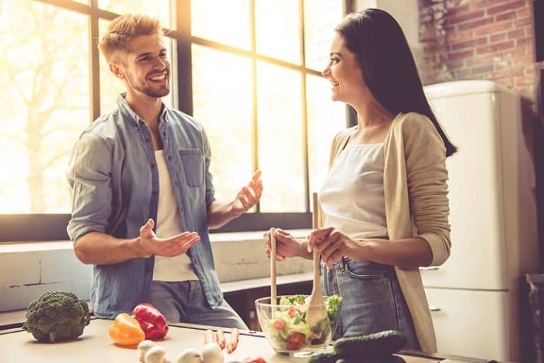 la femme fait le déjeuner et parle à l'homme