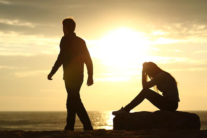 silhouette de couple triste sur la plage