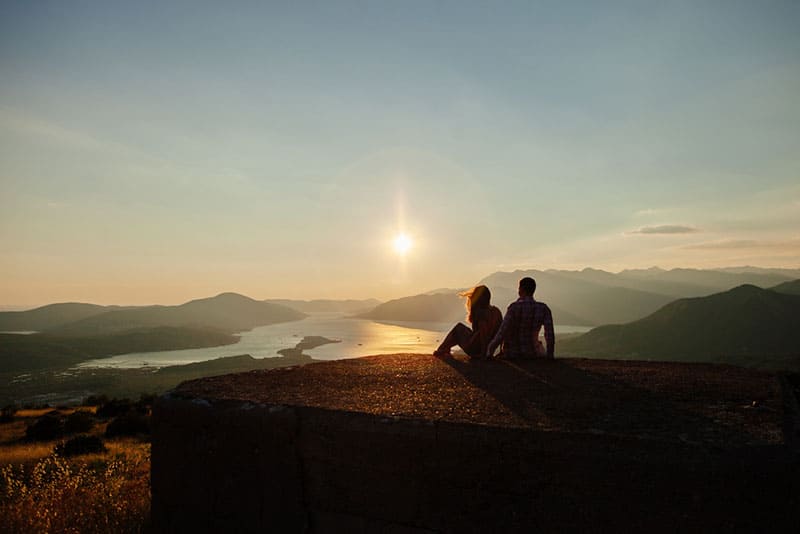 silhouette d'un jeune couple heureux en regardant le coucher du soleil