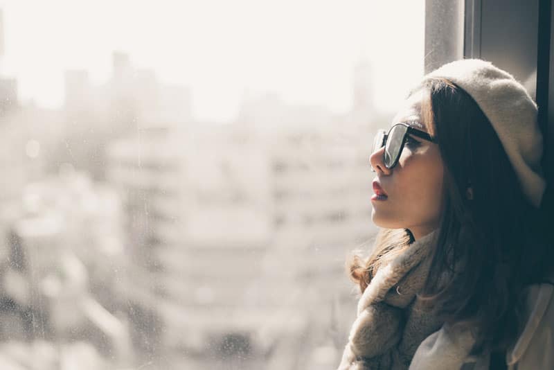 triste jeune femme asiatique par la fenêtre