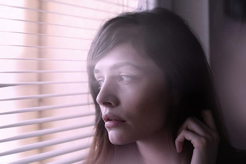 triste jeune femme par fenêtre