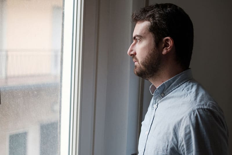triste jeune homme près de la fenêtre