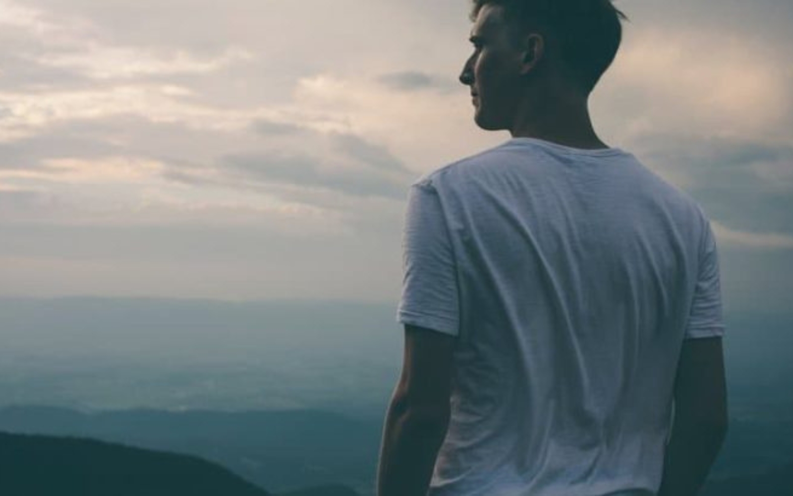 un homme est assis a boire du cafe et a regarder la distance