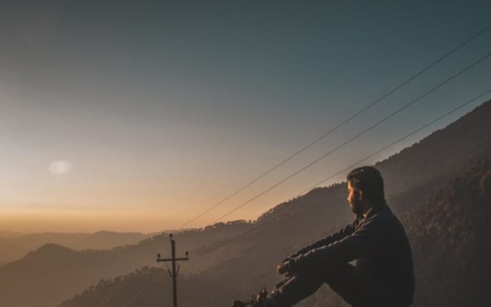 un homme triste assis sur une montagne